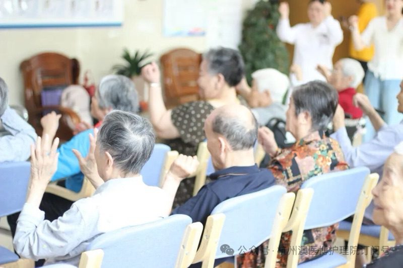 Residents seated in rows with their hands raised during the session