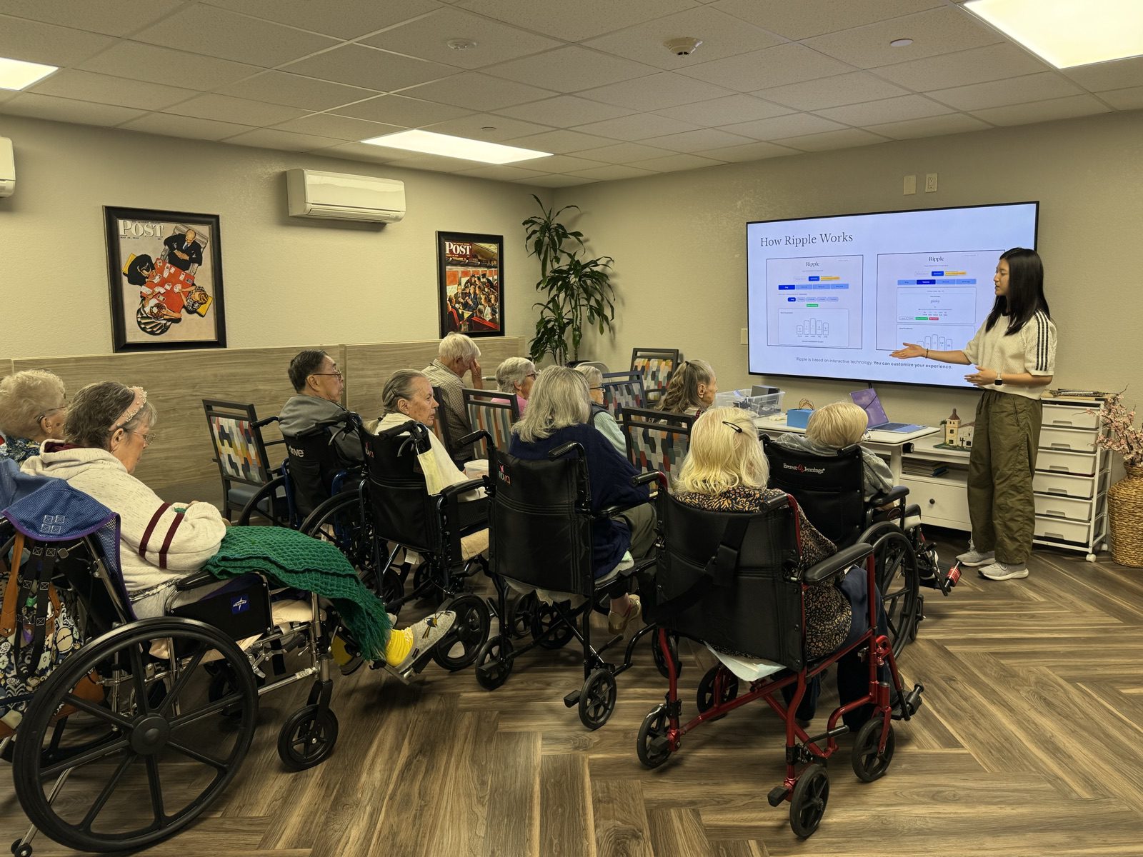 Yanzi presenting a slide titled How Ripple Works to a room of residents seated in wheelchairs